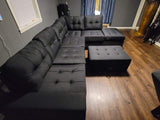 Black linen reversible tufted sectional with drop down cup holders and storage ottoman